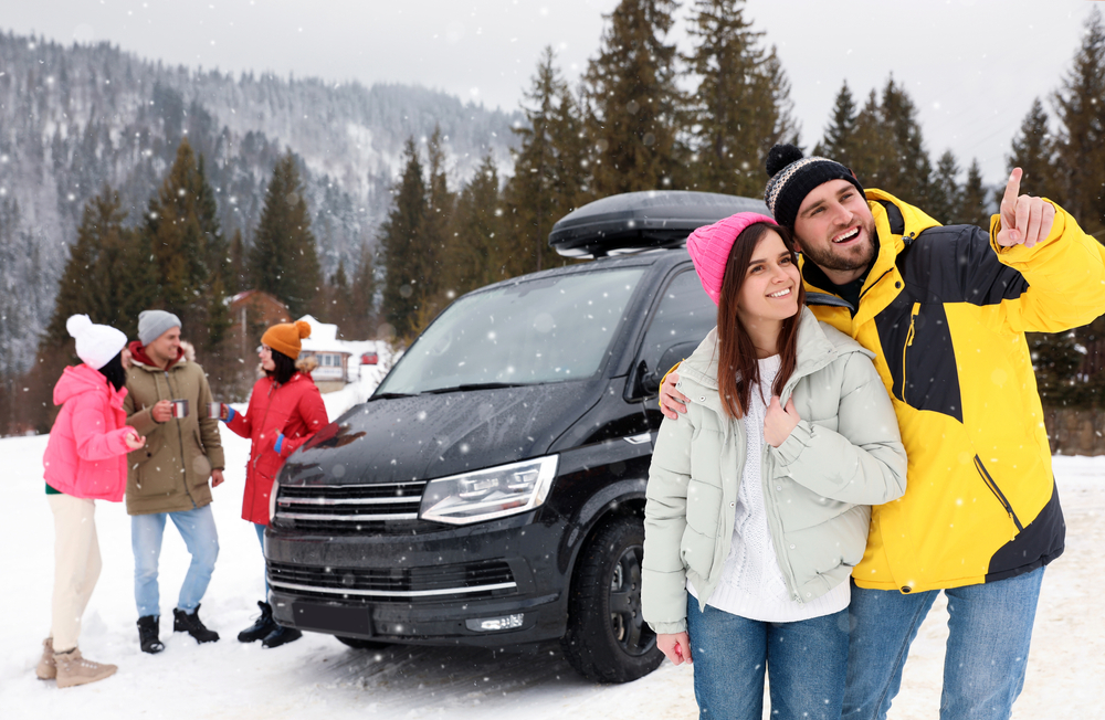 Happy couple and their friends near car on snowy road. Winter vacation Happy couple and their friends near car on snowy road. Winter vacation